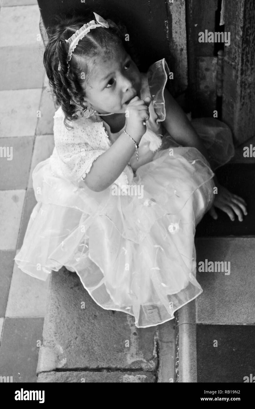 A little girl in her white dress for the holiday of the Holy Virgin in Granada, Nicaragua Stock Photo