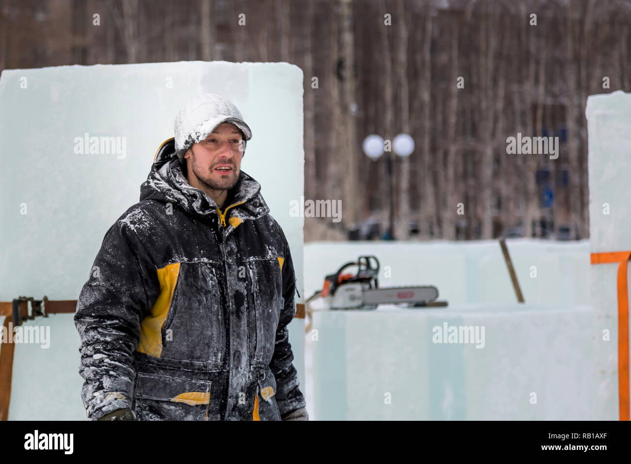 Portrait of an assembler worker in a jacket with a hood at the construction of an ice camp Stock Photo