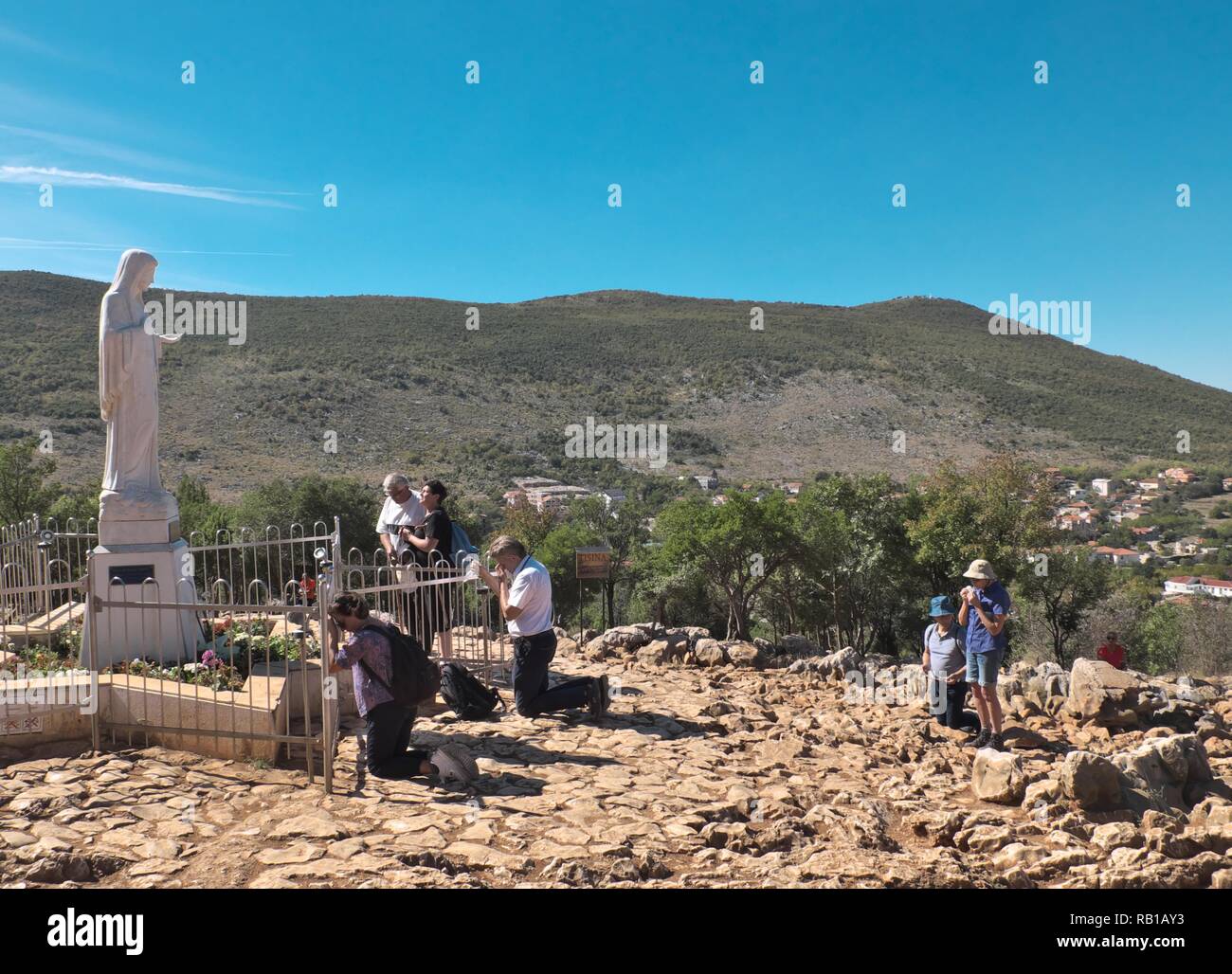 View of the Virgin Mary on Apparition Hill in Bosnia & Herzegovina  during a bright summer day showing lots of people praying Stock Photo