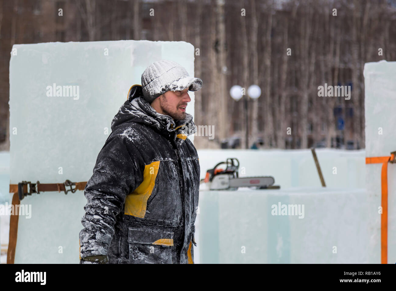 Portrait of an assembler worker in a jacket with a hood at the construction of an ice camp Stock Photo