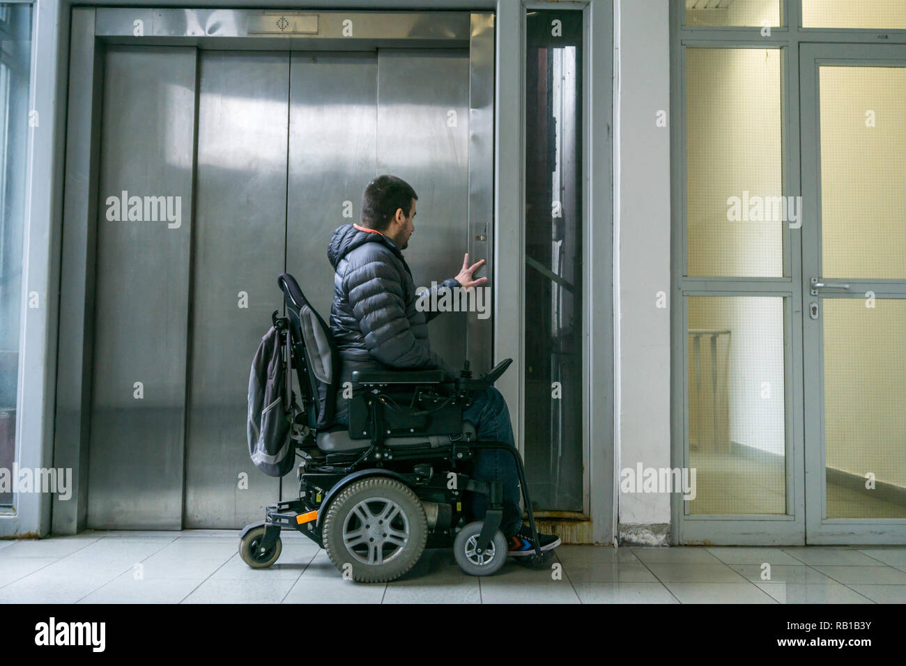 Handicapped male on wheelchair waiting for elevator Stock Photo