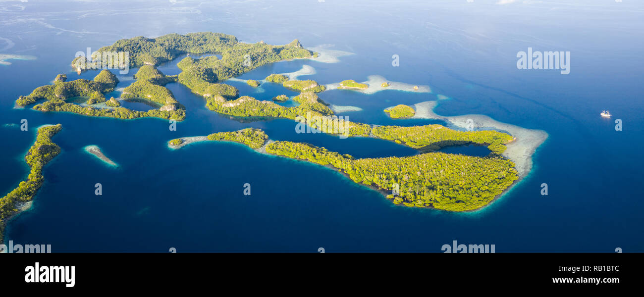 Remote limestone islands rise from the stunning seascape in Raja Ampat, Indonesia. This diverse region is known as the heart of the Coral Triangle. Stock Photo