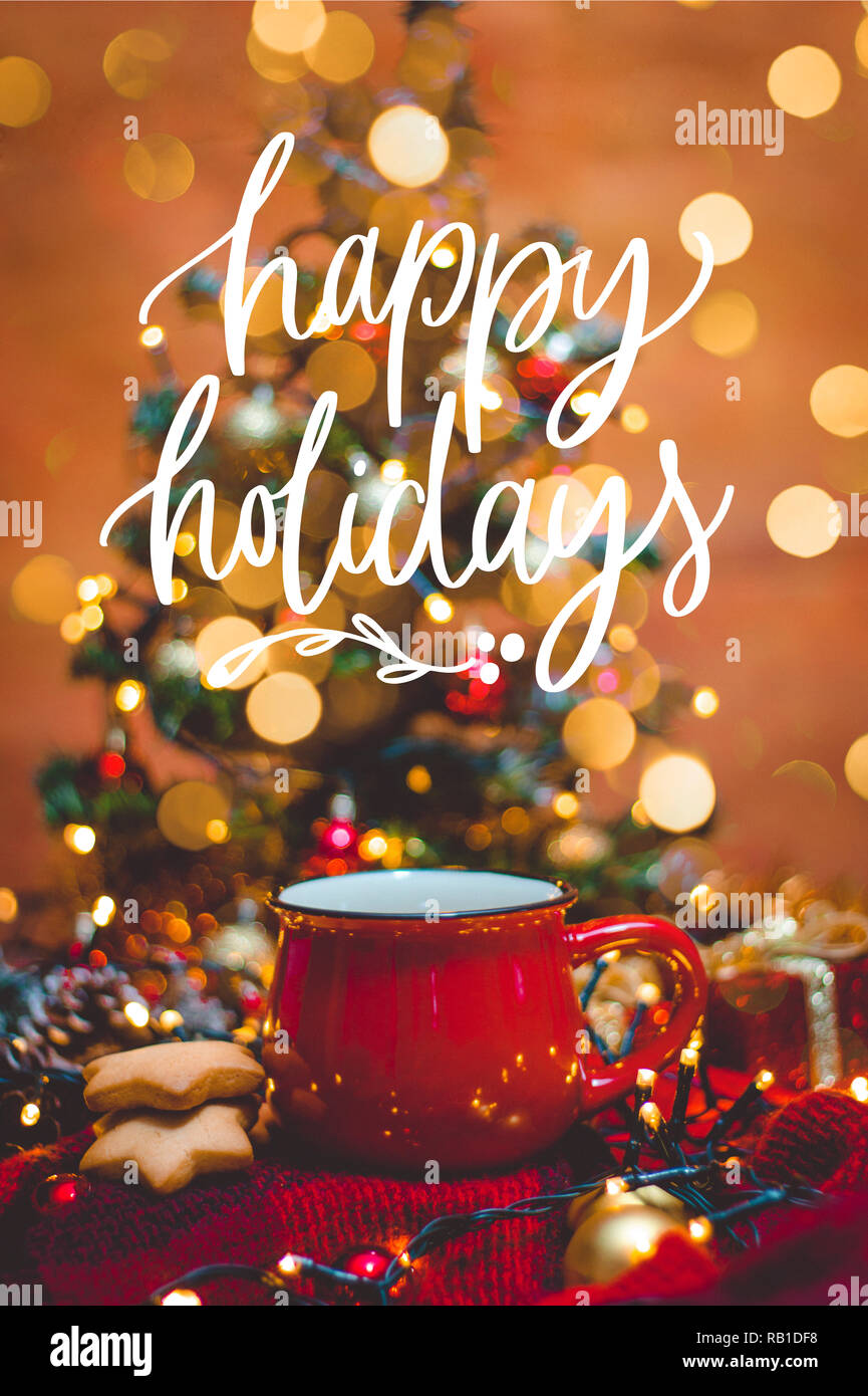 Red mug of hot coffee with Christmas lights, fresh cookies and sparkly  decoration with quote Happy Holidays Stock Photo - Alamy, image size:865x1390