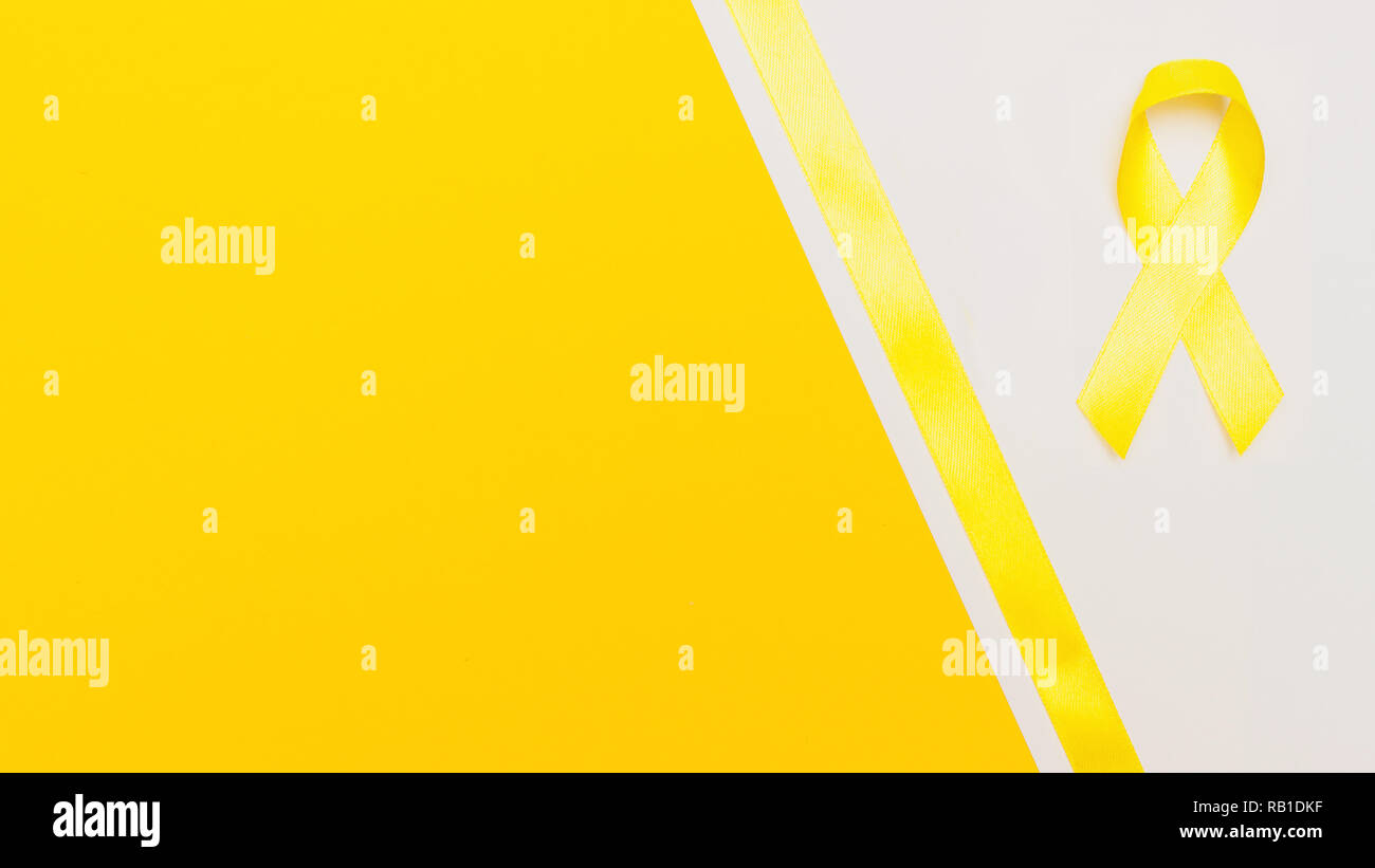yellow cancer awareness ribbon with trail on white background. concept