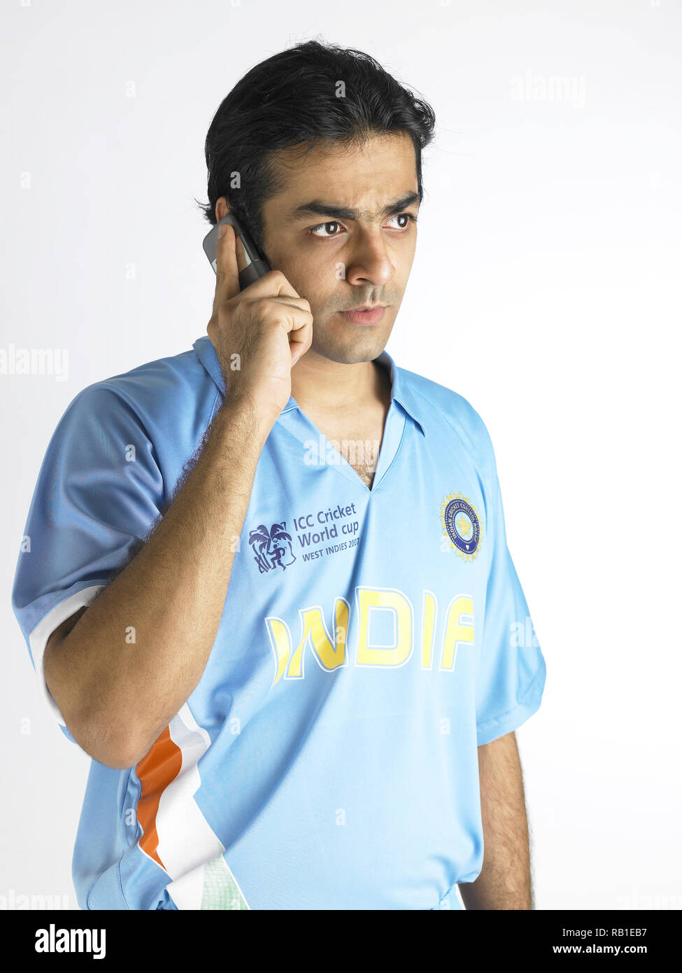 PORTRAIT OF A CRICKET PLAYER  TALKING ON THE MOBILE PHONE Stock Photo