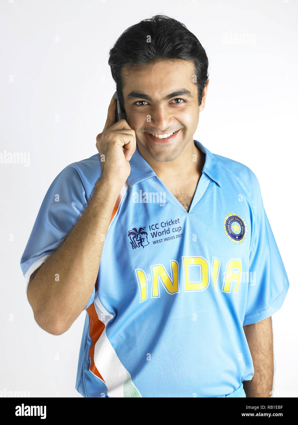 PORTRAIT OF A CRICKET PLAYER TALKING ON THE MOBILE PHONE Stock Photo