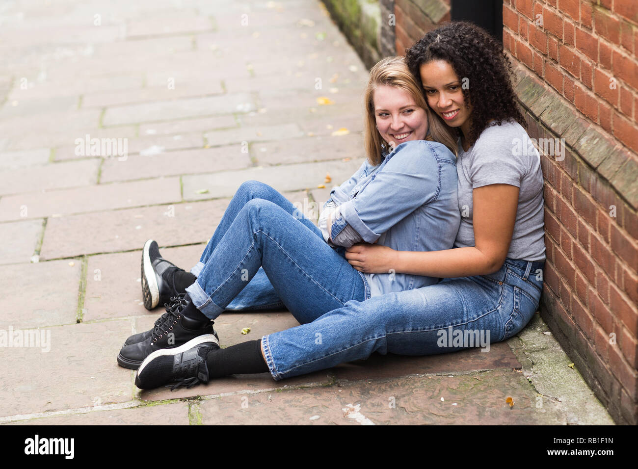 lesbian couple sitting together in the street Stock Photo - Alamy