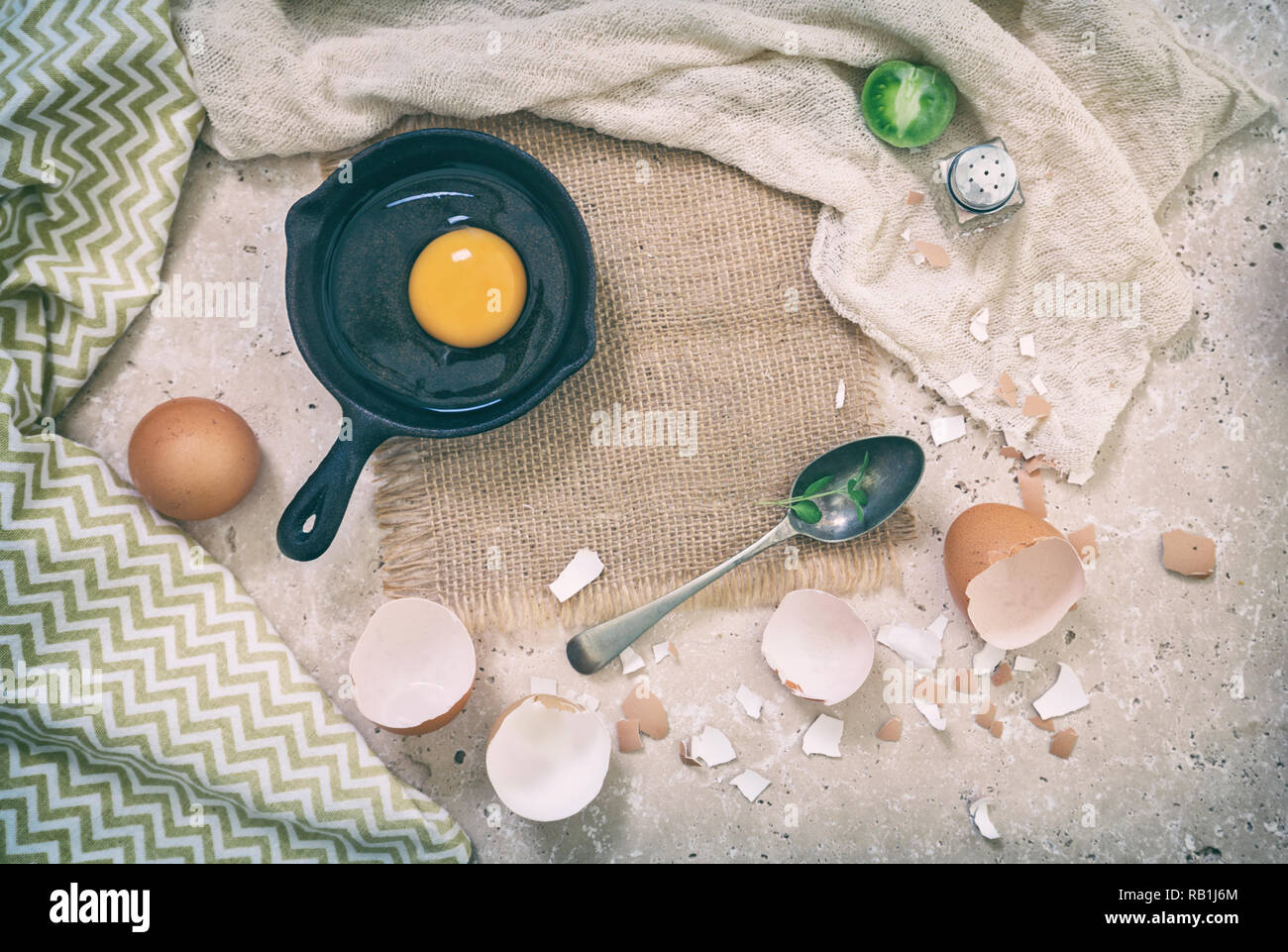 Organic chicken egg in cast iron and cracked shells on the top of