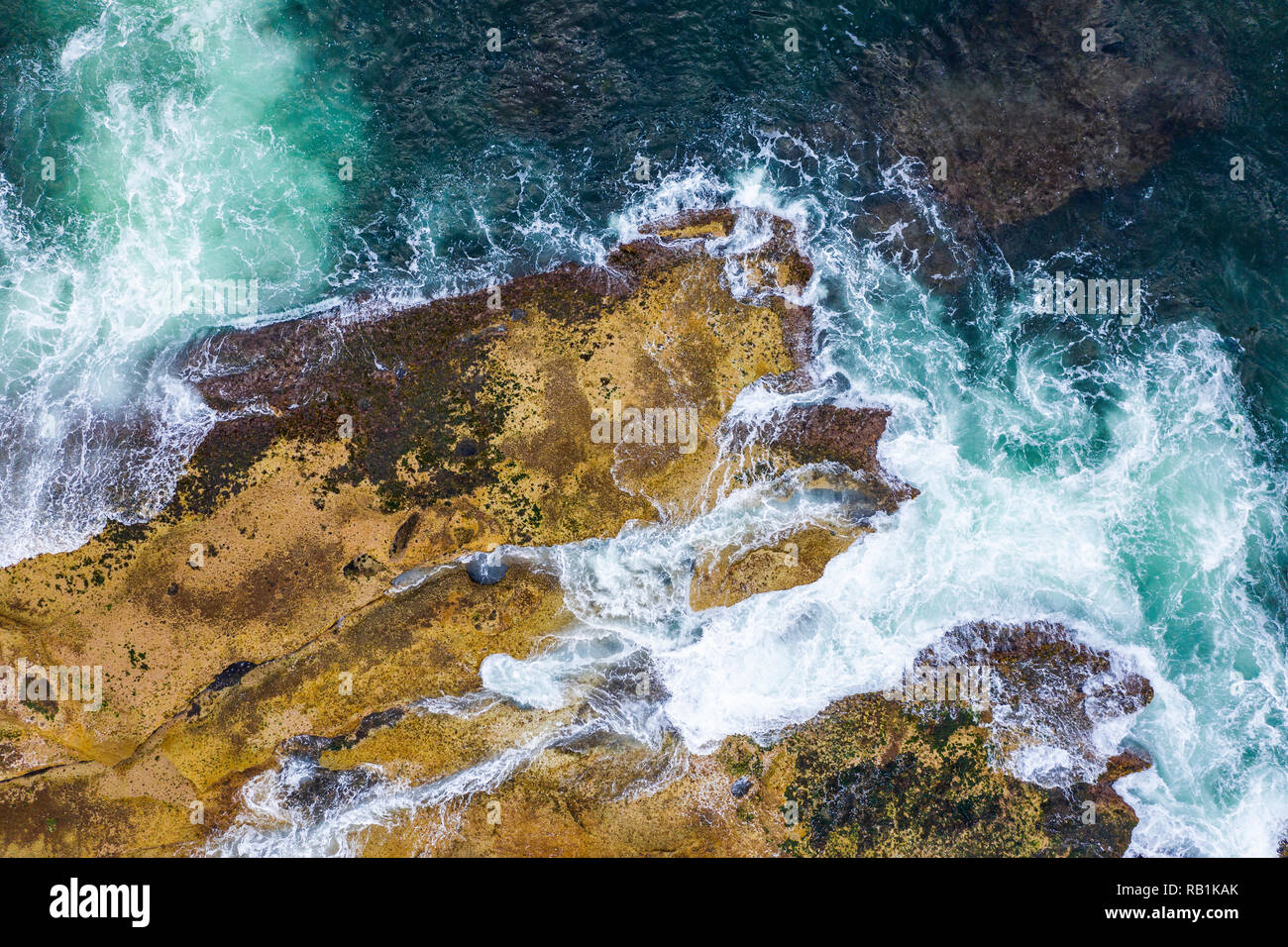 Aerial, overhead view of waves and a rocky shoreline in Sydney, Australia Stock Photo