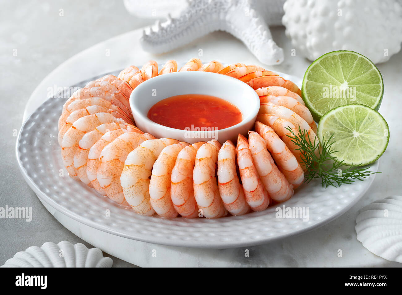 Close-up on shrimp ring with sweet chili sause with dill and lime slices Stock Photo