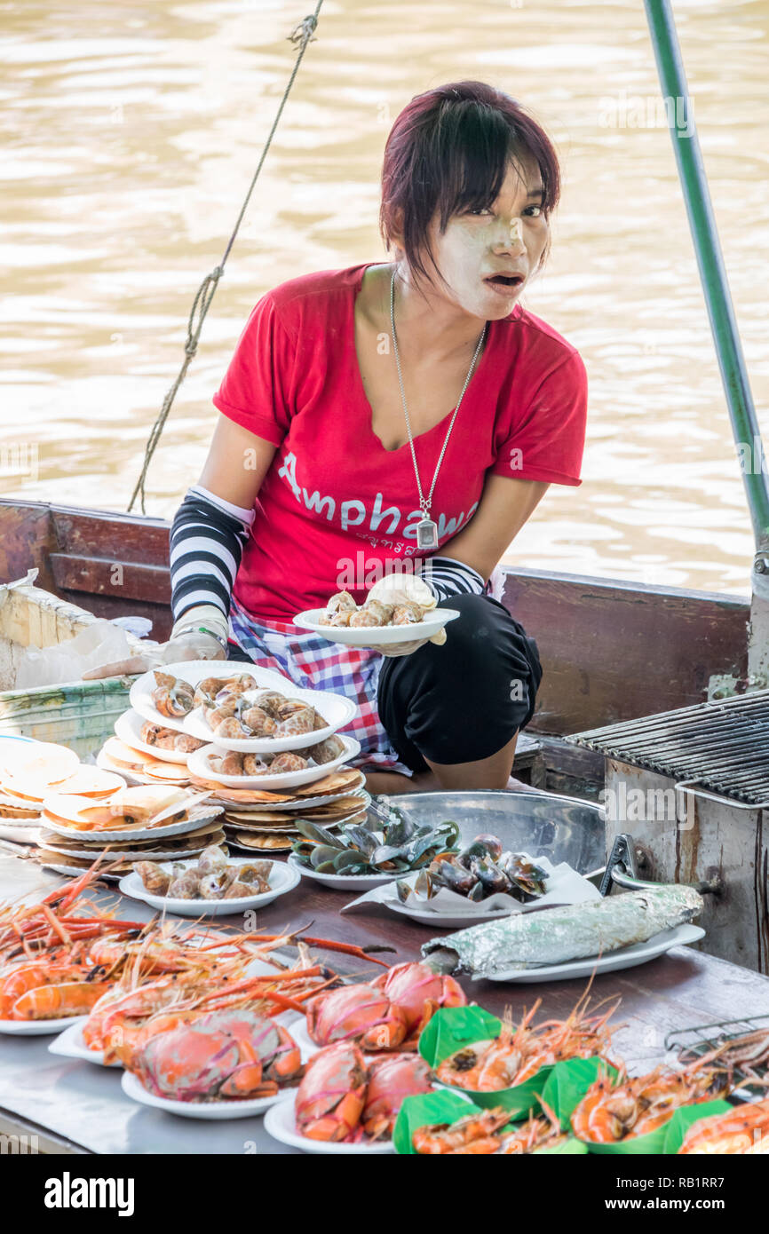 Amphawa, Thailand - 7th October 2018: Grilling and selling seafood from a boat, A floating market is held every weekend. Stock Photo
