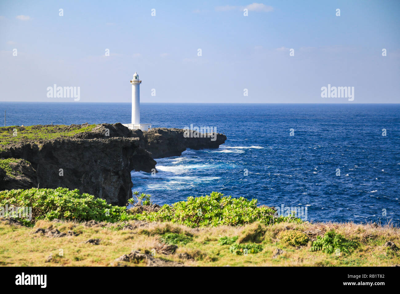 white lighthouse in cape zanpa in Japan with blue sea and sky Stock Photo
