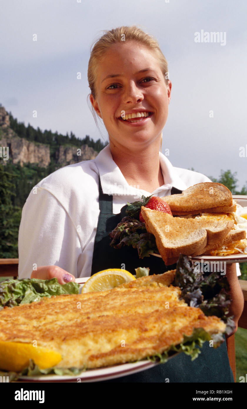 Young Waitress Delivers a Fried Fish and Eggs Breakfast Platter