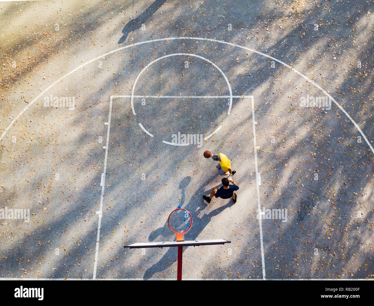 Father and son playing basketball in the park aerial view Stock Photo