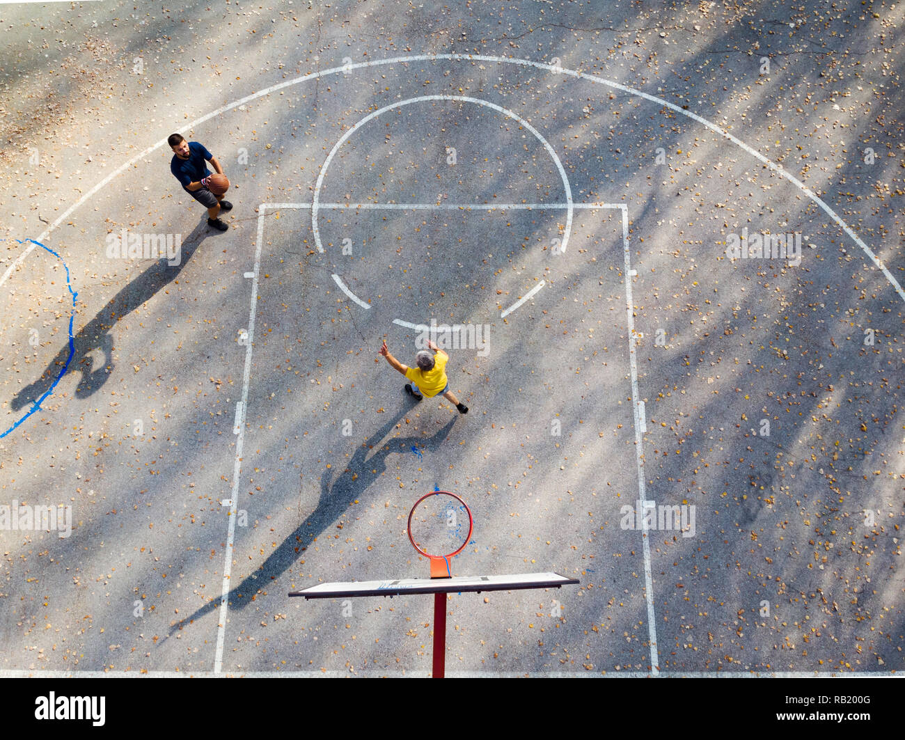 Father and son playing basketball in the park aerial view Stock Photo