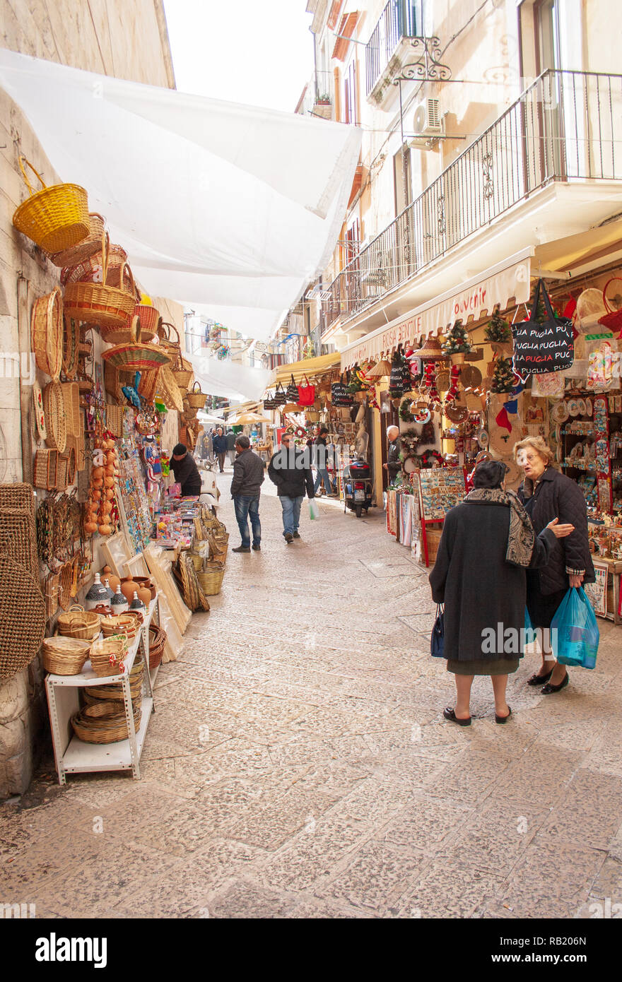 View of a narrow street in  Bari, Puglia, Italy, Bari vecchia, traditional open market shops with souvenir for tourists, vertical Stock Photo