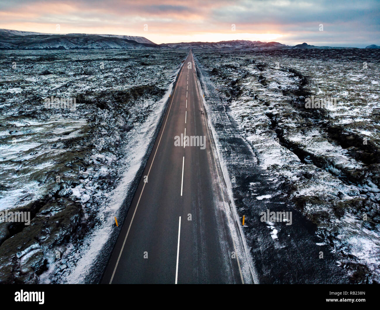 Road in Iceland surrounded by lava fields covered with snow aerial view Stock Photo