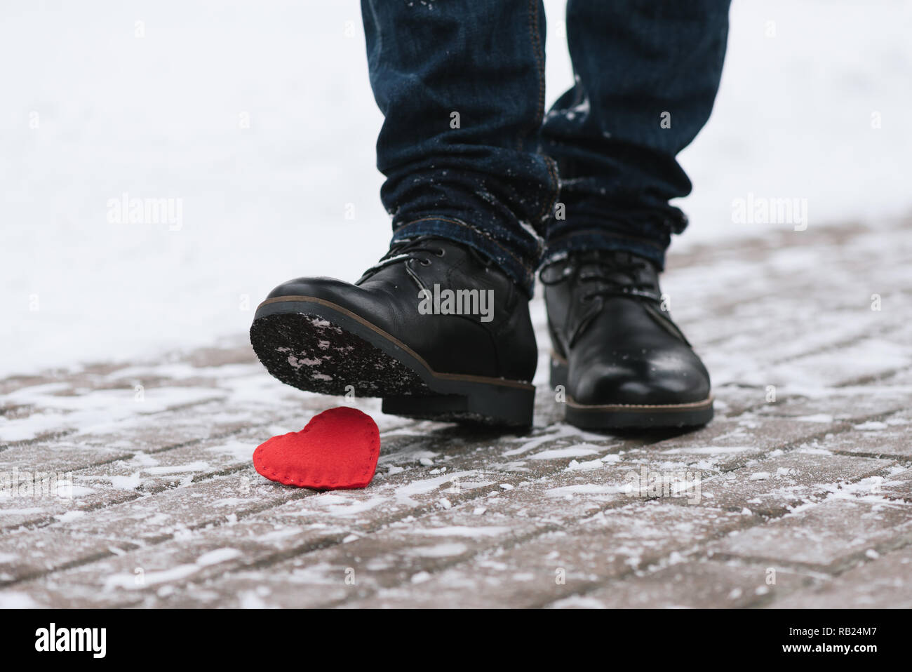 Tramples love. Symbol of separation. A man stepped on a shoe decorative heart Stock Photo