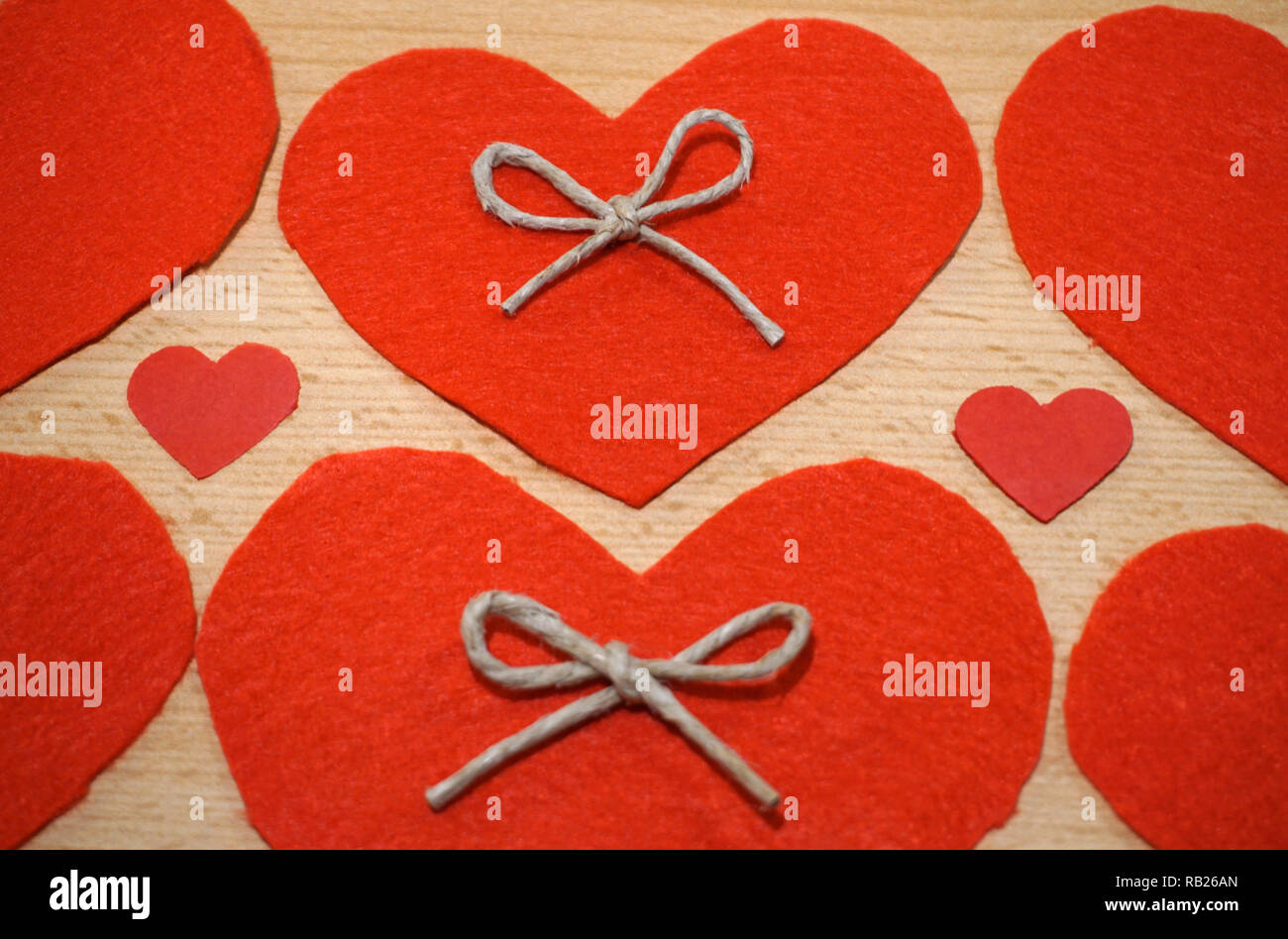 Love and Valentines Day background with handmade hearts from red felt on wooden background Stock Photo