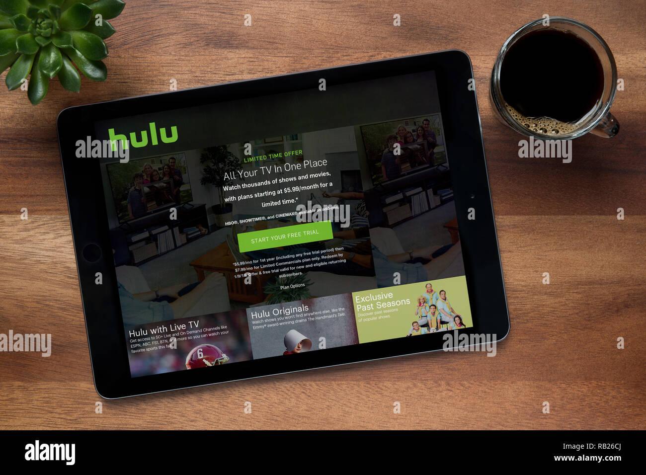 The website of Hulu is seen on an iPad tablet, on a wooden table along with an espresso coffee and a house plant (Editorial use only). Stock Photo