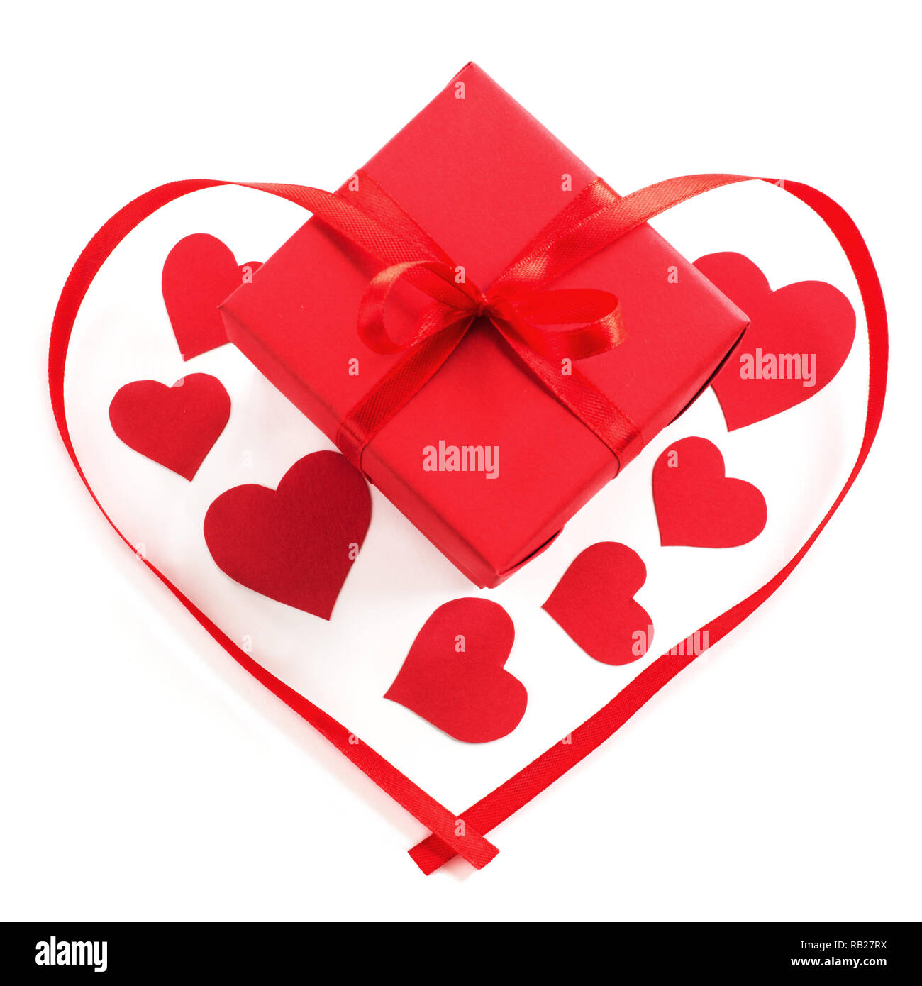 Small red gift box with ribbon bow and paper hearts studio isolated on ...