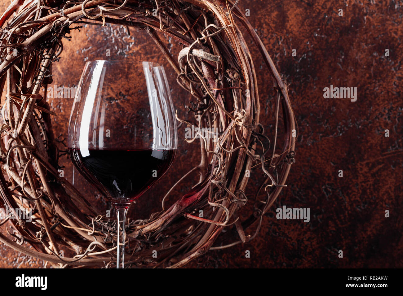 Vine wreath and glass of red wine on a vintage background. Copy space for your text. Stock Photo