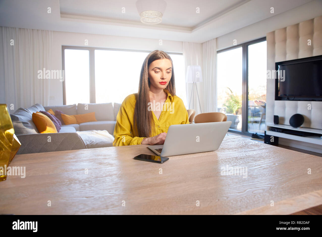 Shot of confident young woman using laptop while working from home. Home office. Stock Photo