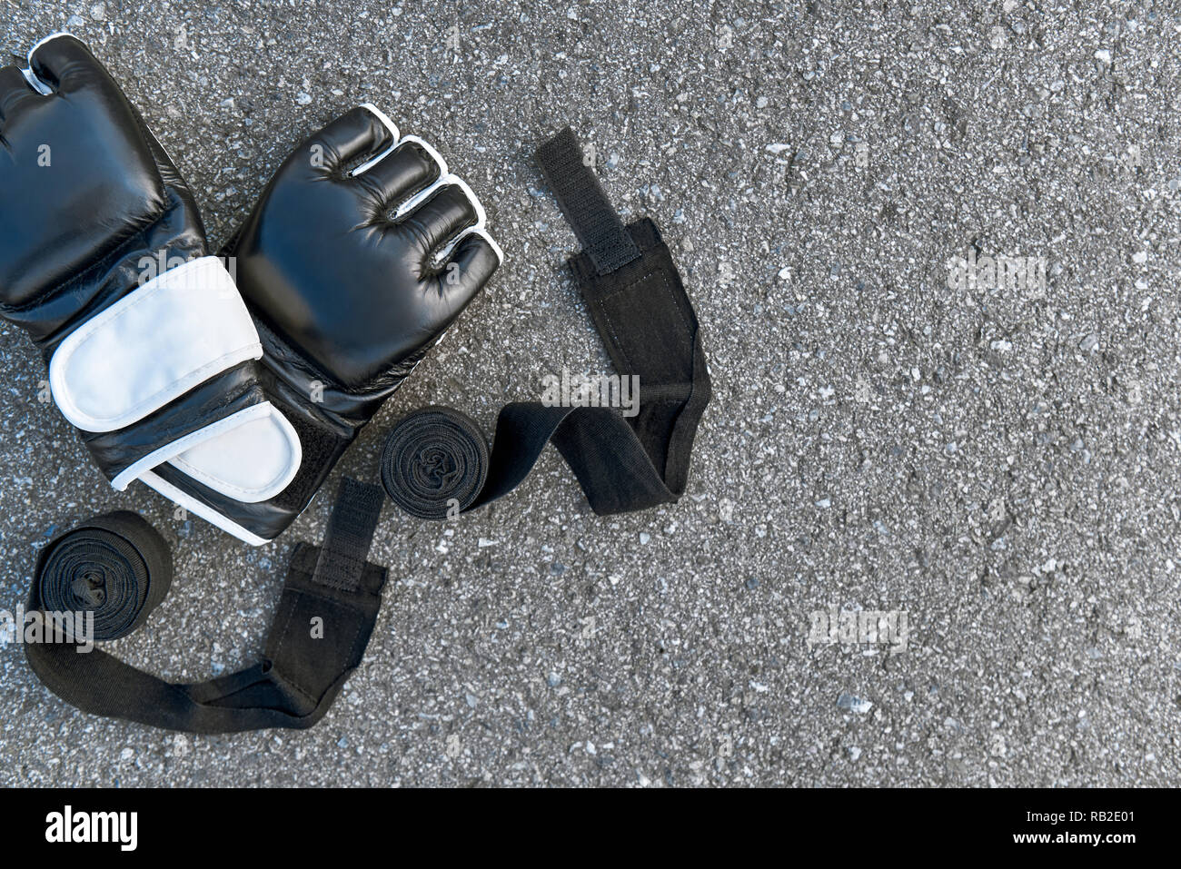 Motivated to fight. Close-up of sports boxing gloves with boxing bandages at the asphalt background Stock Photo