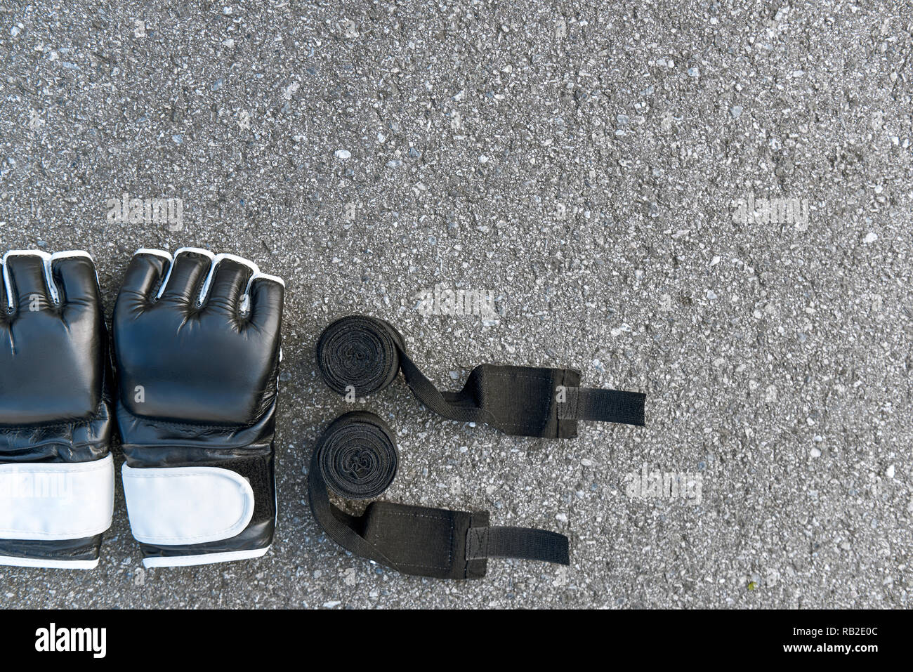 Best sports items. Close-up of sports boxing gloves with boxing bandages at the asphalt background Stock Photo