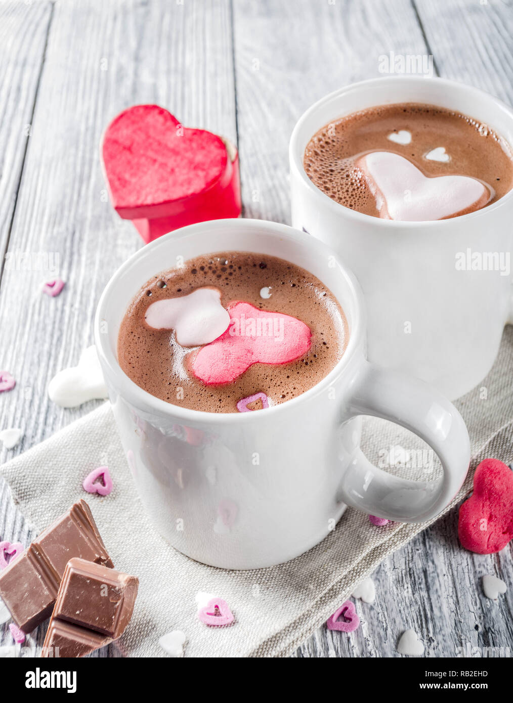 https://c8.alamy.com/comp/RB2EHD/valentines-day-treat-ideas-two-cups-hot-chocolate-drink-with-marshmallow-hearts-red-pink-white-color-with-chocolate-pieces-sugar-sprinkles-old-wood-RB2EHD.jpg