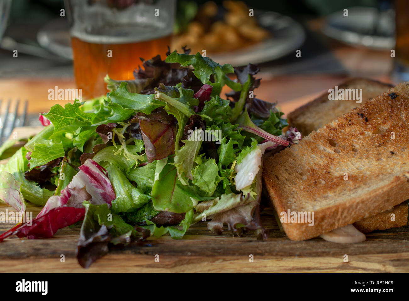 Grilled cheese sandwitch with salad and beer in a restaurant setting close-up side view Stock Photo