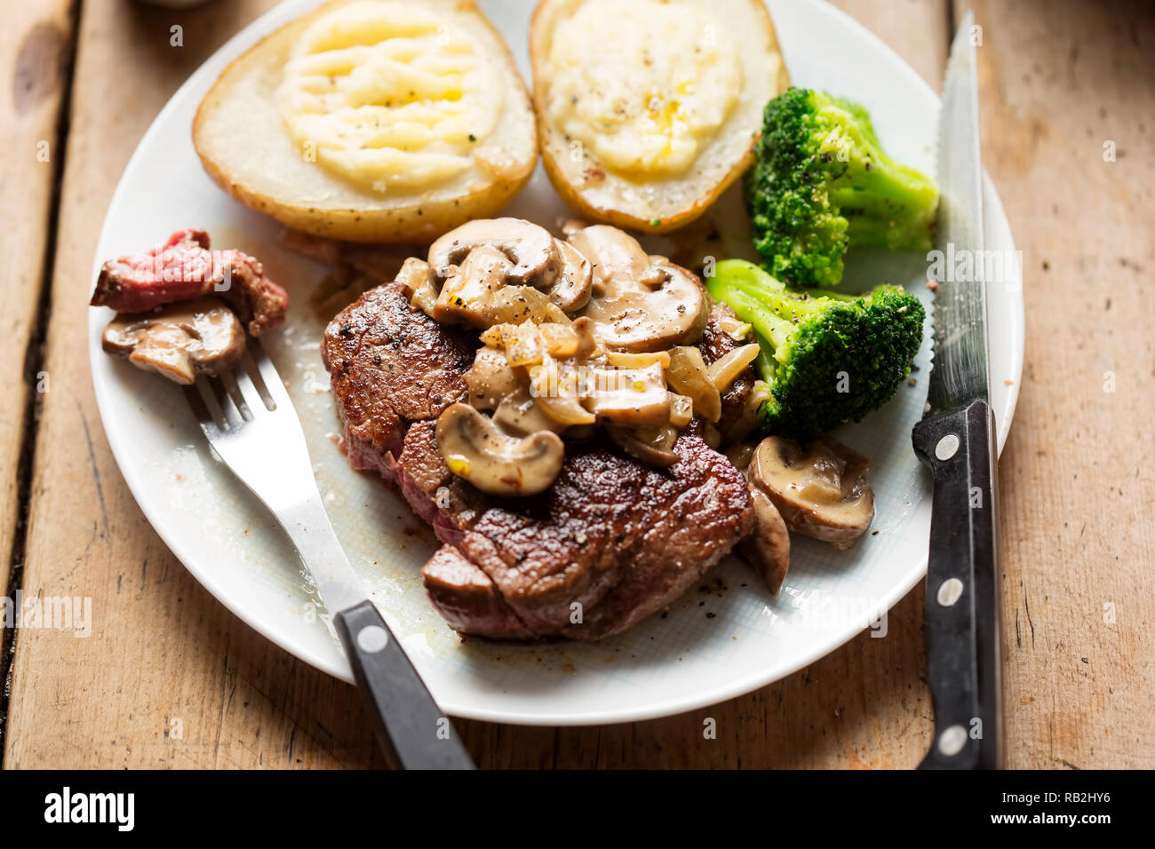 Steak with mushroom sauce, baked potatoes, broccoli Stock Photo