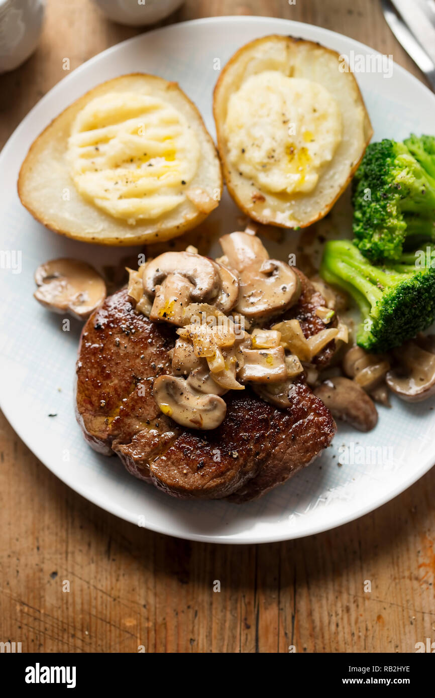 Steak with mushroom sauce, baked potatoes, broccoli Stock Photo Alamy