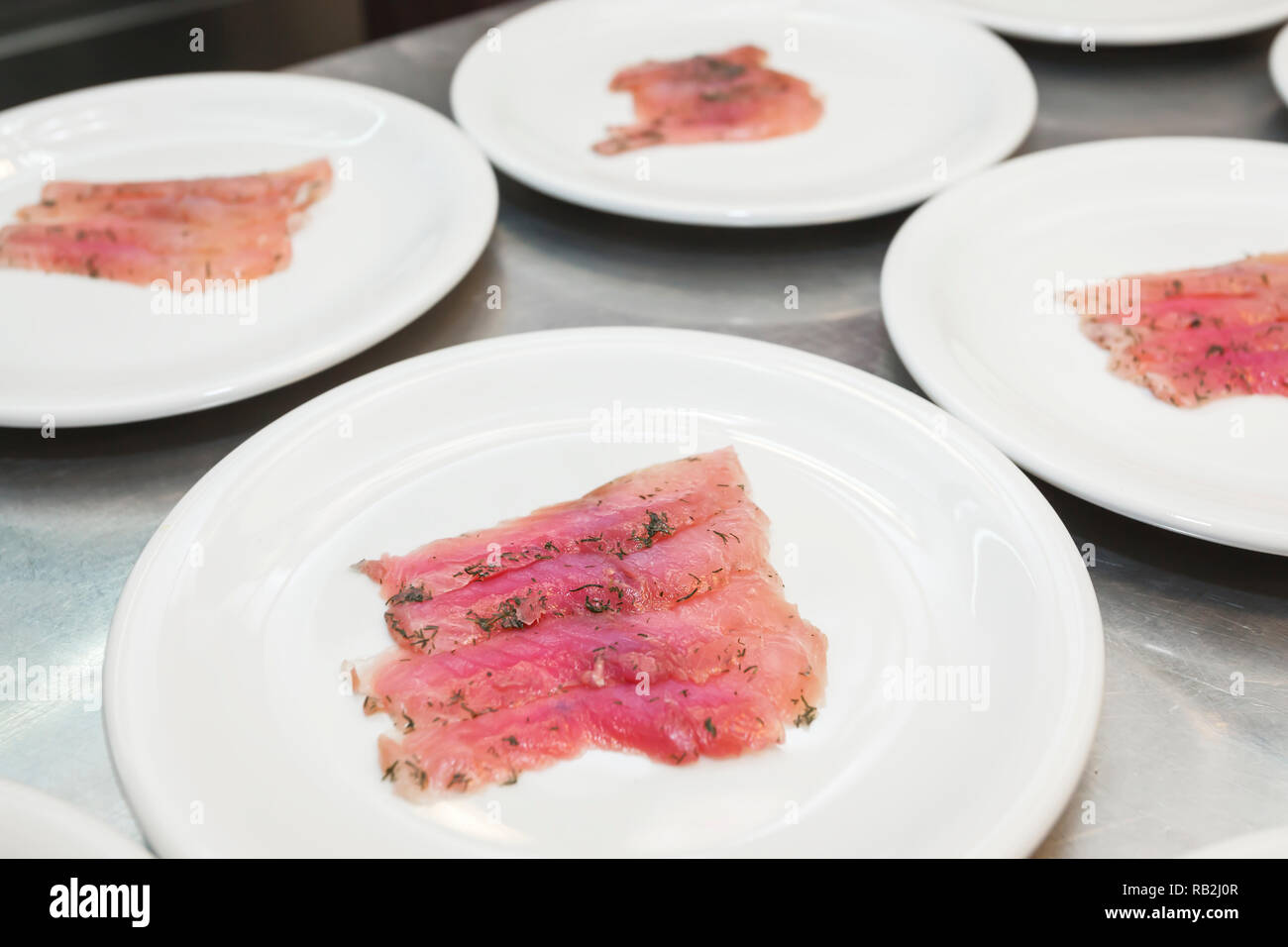 Serving posh antipasto with fish carpaccio, wasabi and salad dressing