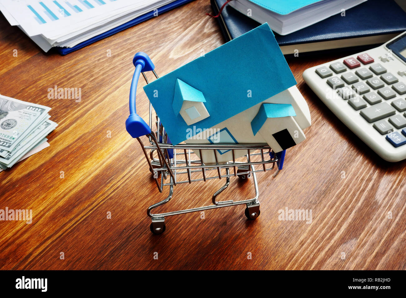 Property investment. Model of home in the trolley. Stock Photo