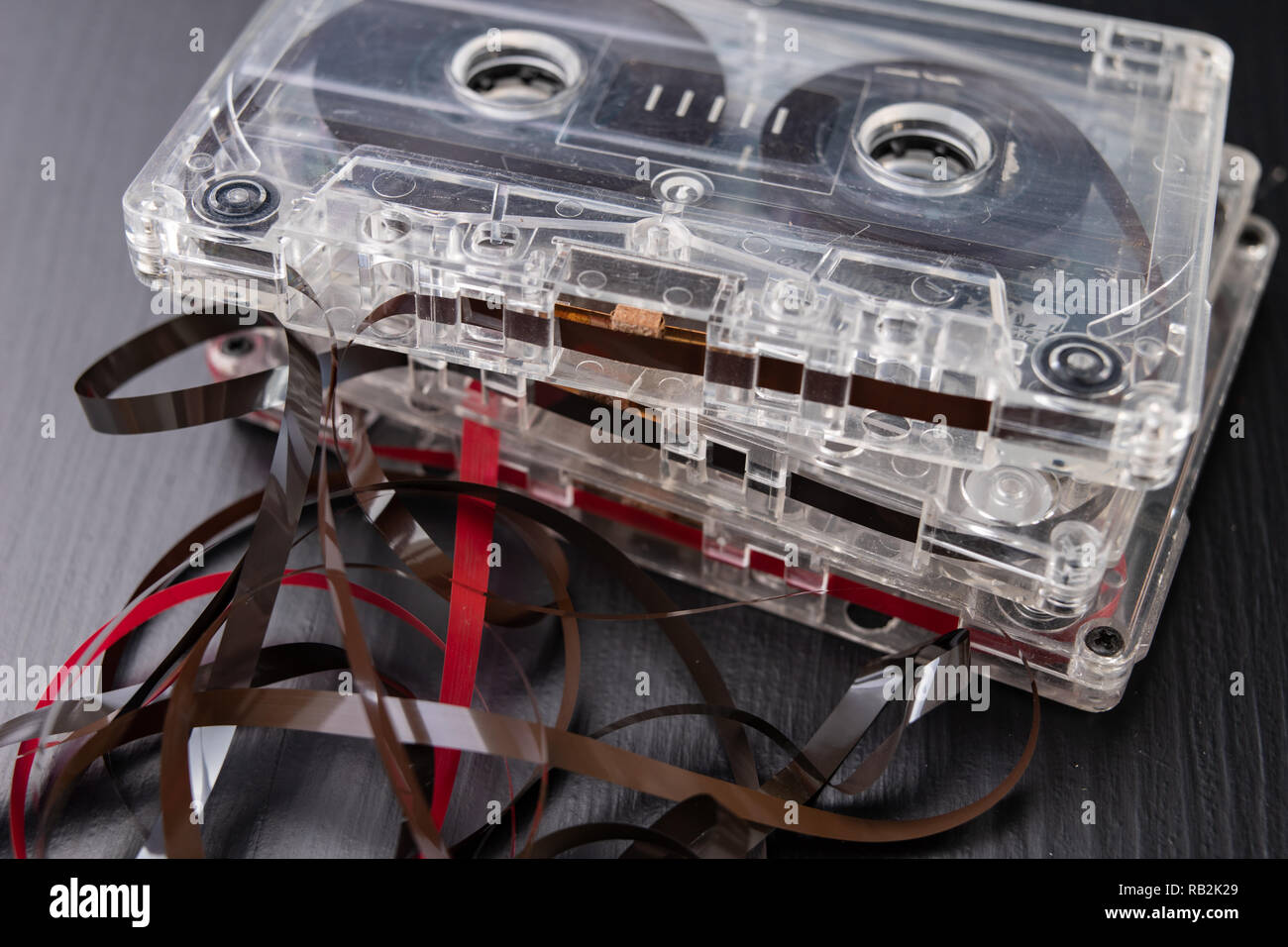 Audio cassette and pencil on a black table. Old data carrier. Dark background Stock