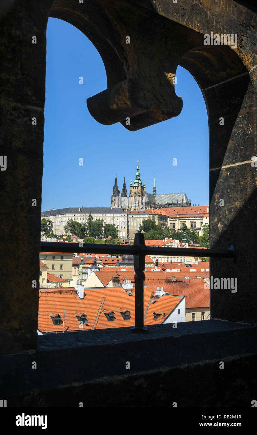 PRAGUE, CZECH REPUBLIC - JULY 2018: View of Prague's St Vitas Cathedral framed by a stone arch on the top of the Lesser Town Bridge Tower. Stock Photo