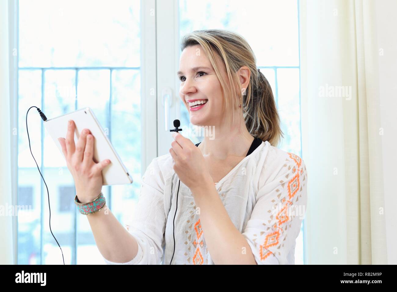 A Woman communicating online in a webinar Blog or internet with tablet PC Stock Photo