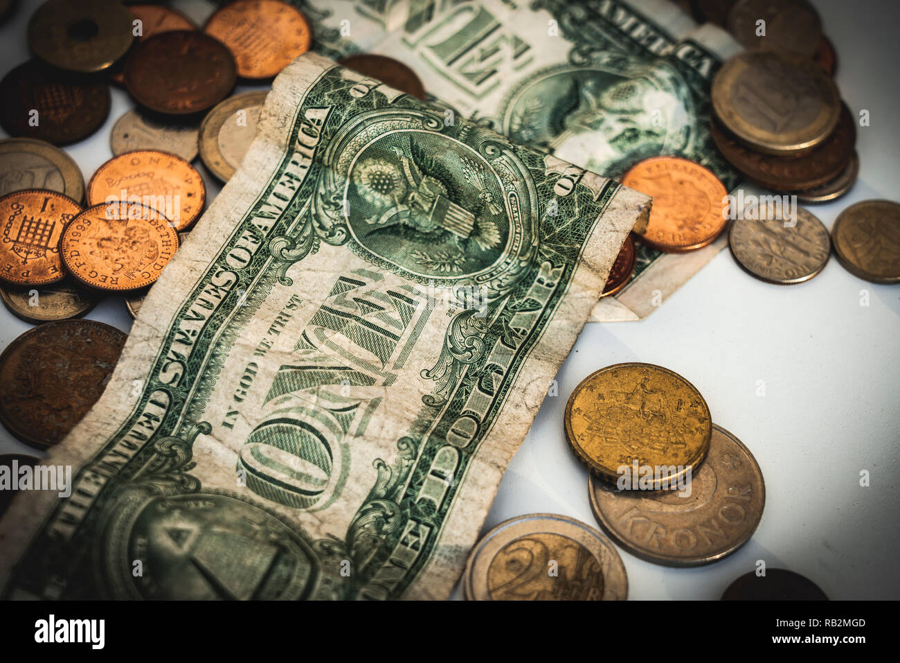 Coins and dollar bills scattered on white table. Money and economy ...