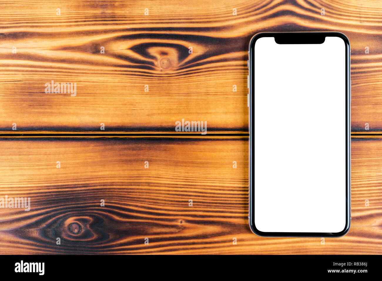 Frameless mockup smartphone with blank screen on office desk. Isolated