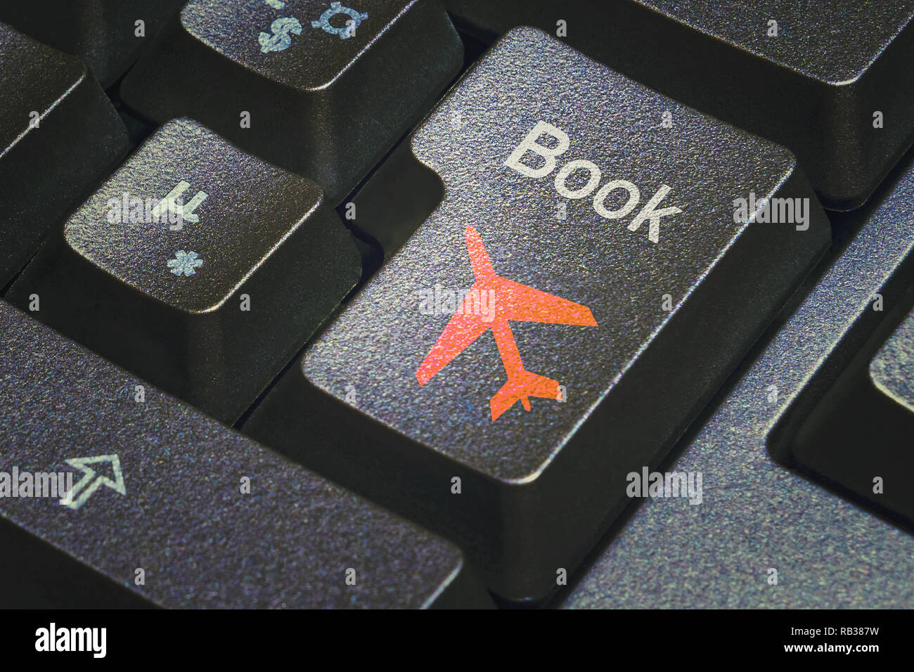 Book flight push button on a black keyboard with airplane icon. Online booking travel concepts. Stock Photo