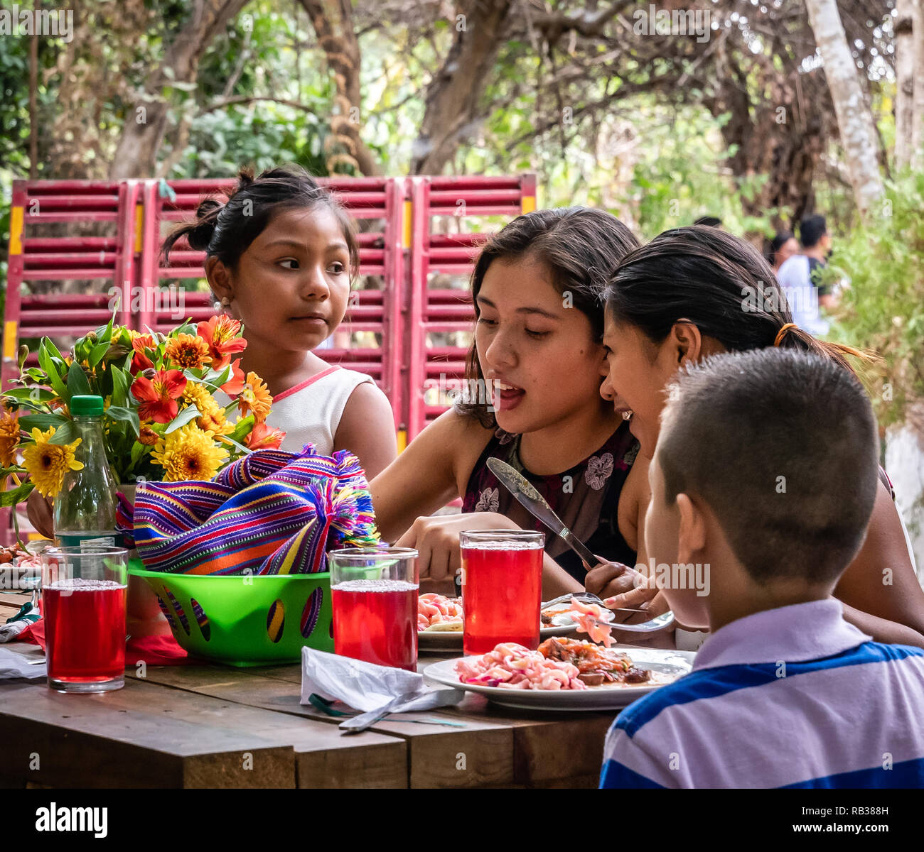 latin children sitting at picnic table eating at party in Guatemala