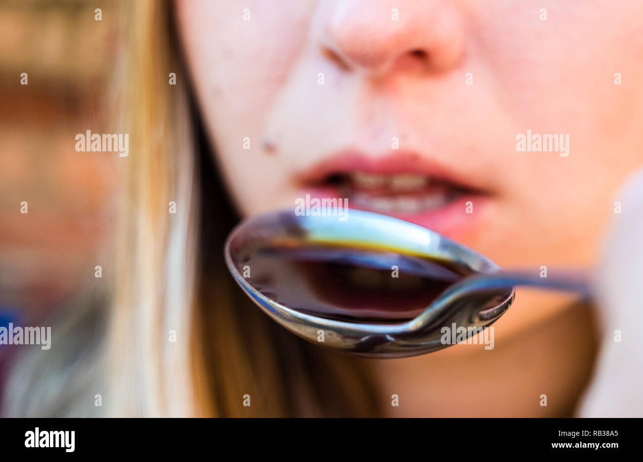 young woman takes cough syrup Stock Photo Alamy