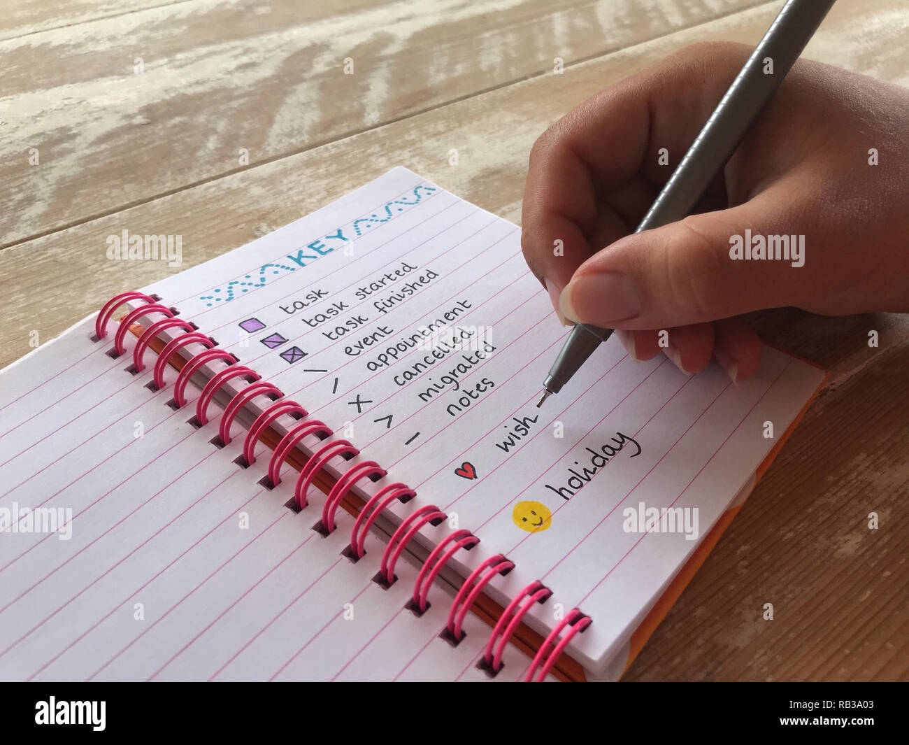 millennial woman writing in a bullet journal Stock Photo