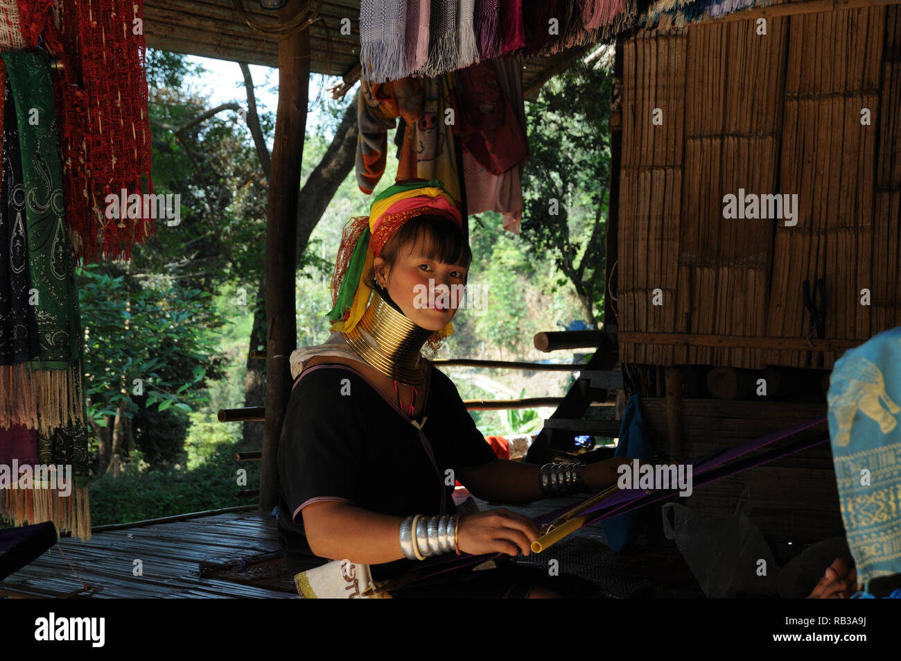 Young Kayan Lahwi woman weaving in a remote mountain village, Chiang Mai Province, Thailand Stock Photo