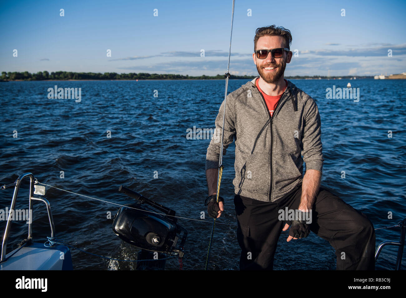 Sailing boat with skipper on a stern Stock Photo Alamy