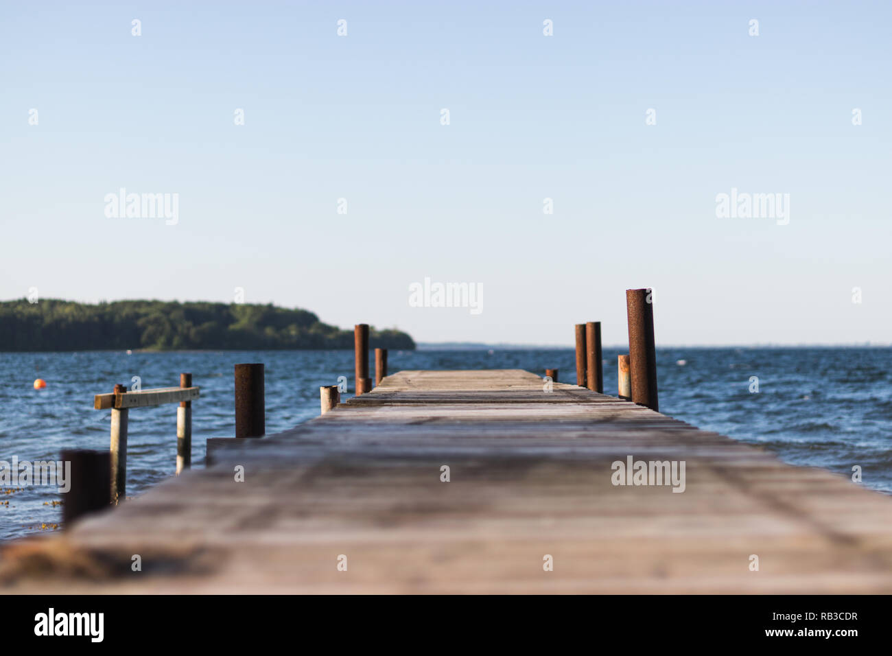 Vintage wooden jetty/pier on the shore of a danish beach. Island in the ...
