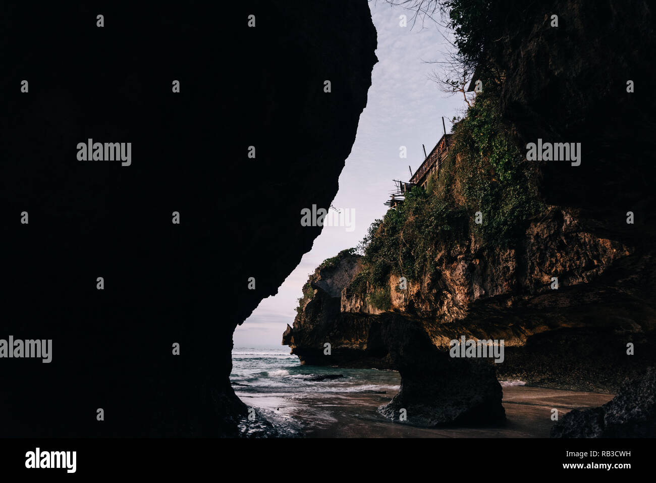 Lonely lagoon called Suluban Surf Beach on Bali, Indonesia. Low tide beach in the evening dawn with blue water and yellow sand with cliffs around Stock Photo