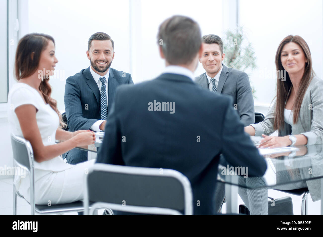 group of business people sitting at a table at an office working ...