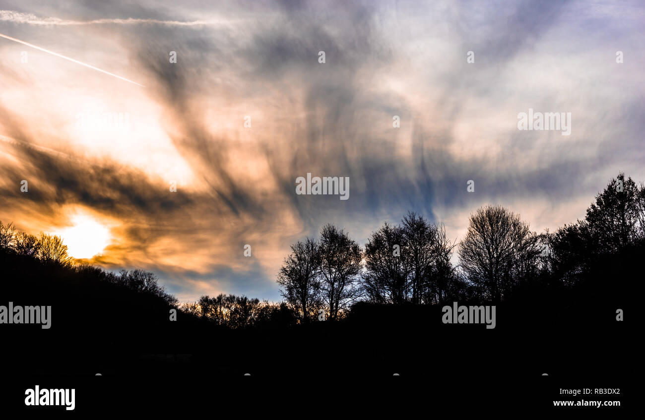 Sunset with dramatic sky with clouds and silhouettes of trees Stock ...